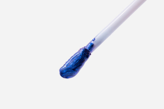 Close-up of blue Stay-On Lip Stain applicator on white background