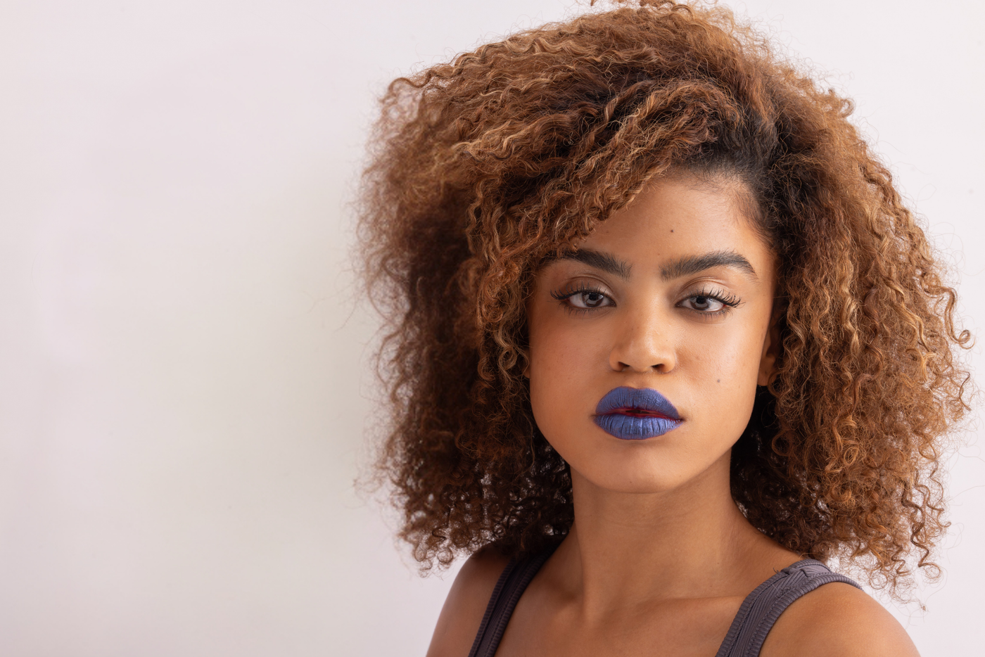 Model wearing blue Stay-On Lip Stain on white background