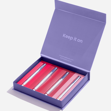 Stained lip stain discovery box with four Stay-On Lip Stain tubes in a purple ‘Keep it on’ gift packaging.