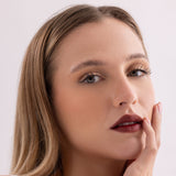 Model wearing Stained lip stain whimsical shade on a clean studio background.