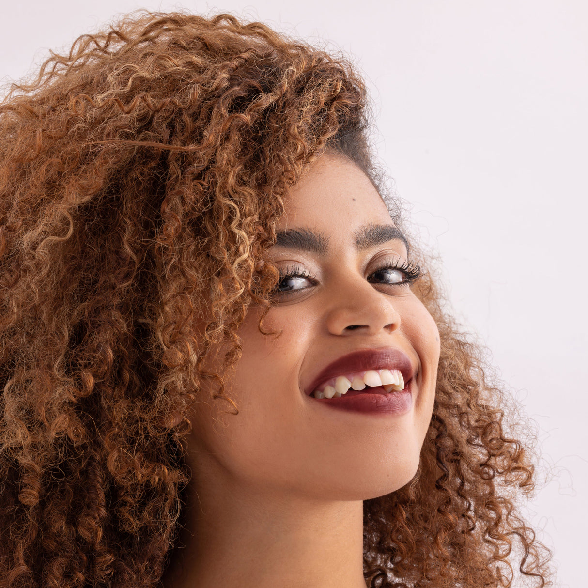 Model wearing Stained lip stain whimsical shade on a clean studio background.