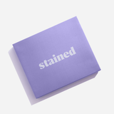 Stained purple gift box packaging with the Stained logo on a white background